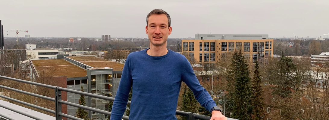 Unser Kollege Jens im blauen Pullover auf der Dachterrasse des AKQUIENT-Büros in Hamburg-Bramfeld.
